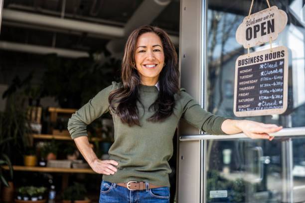 Business Owner Standing at the Front Door of Her Shop